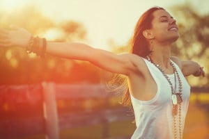 Young woman outstretched arms enjoys the freedom and fresh air